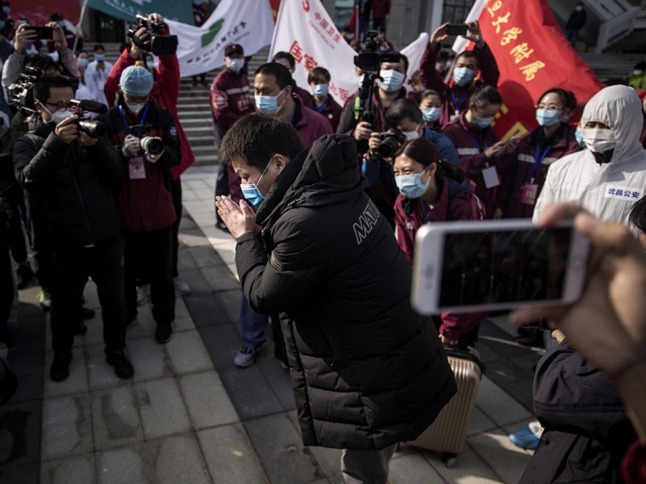 WUHAN, CHINA: A discharged COVID-19 patient bows to doctors while leaving Wuchang Fang Cang makeshif