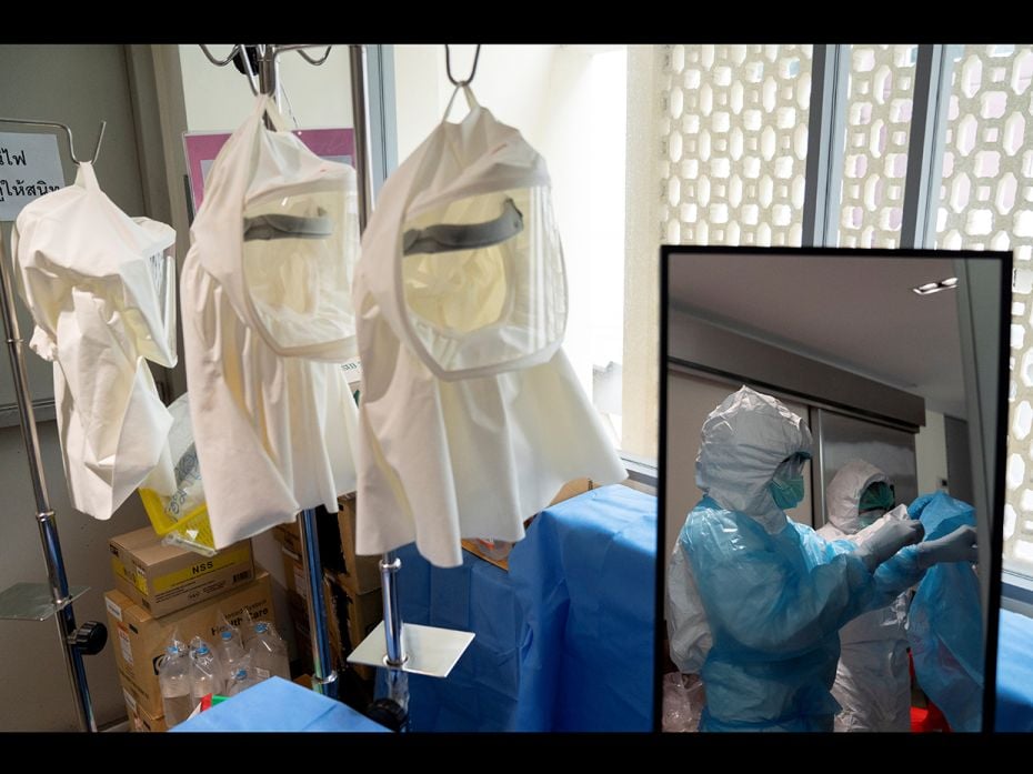 Nurses wearing personal protective equipment (PPE) before entering the room of a Covid-19 patient in