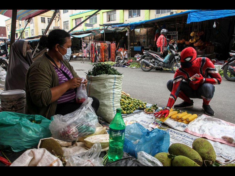 A worker wearing a superhero costume is seen at a traditional market, in Pekanbaru, Riau Province, I