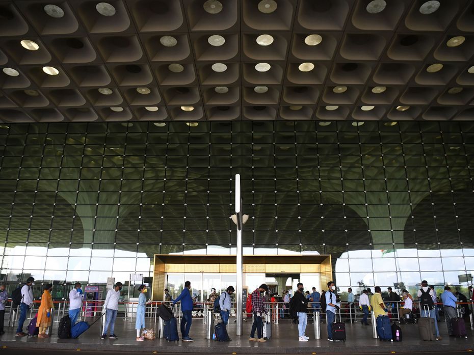 Passengers queue with social distancing norms at the Mumbai airport, to board flights. Confusion and