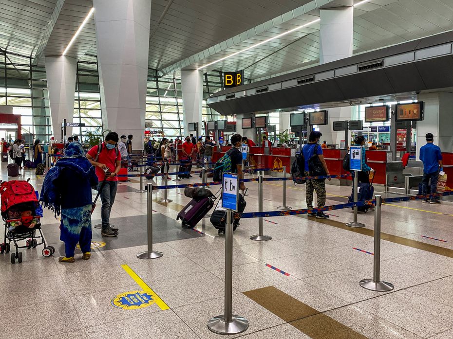 Passengers line up maintaining social distance, to drop their bags at counters in the Indira Gandhi 