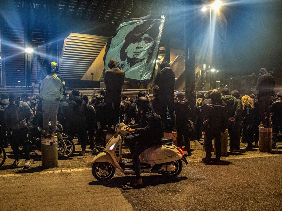 Supporters mourn the death of soccer player Diego Armando Maradona in front of the San Paolo stadium