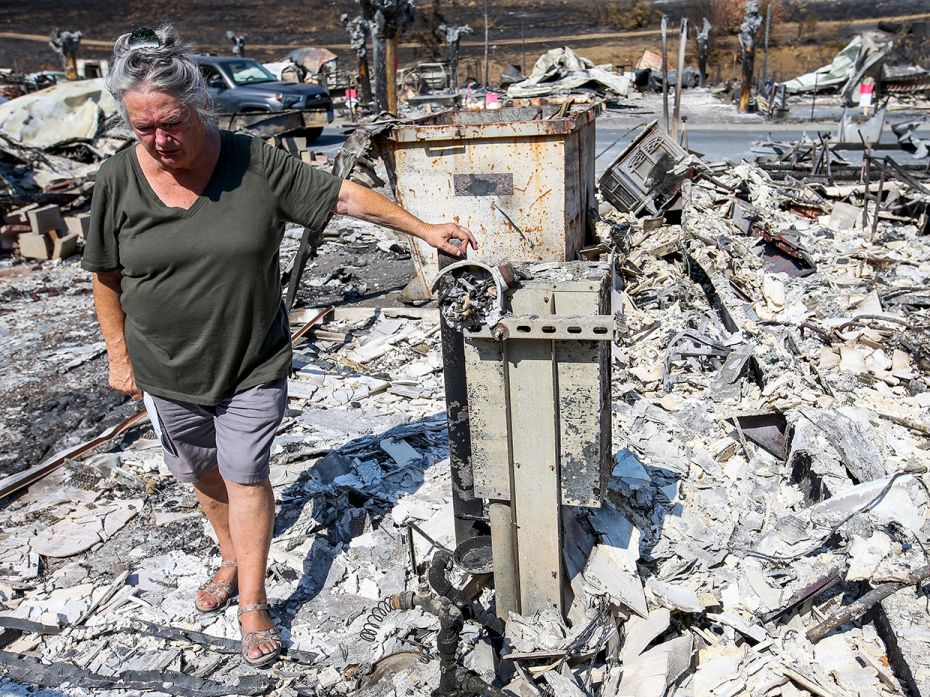 LAKE BERRYESSA, CA - AUGUST 27: Artist Marcia Ritz, 77, pauses  while looking through the rubble of 