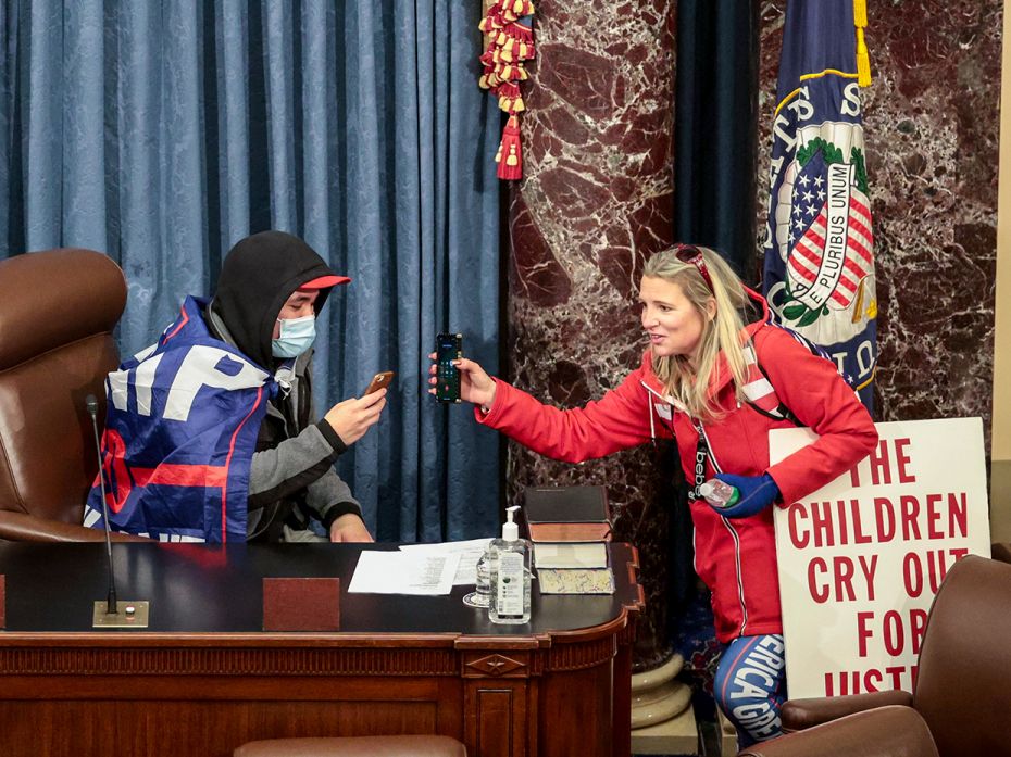 Protesters interacting with each other while sitting in the Senate Chamber on January 6, 2021 in Was