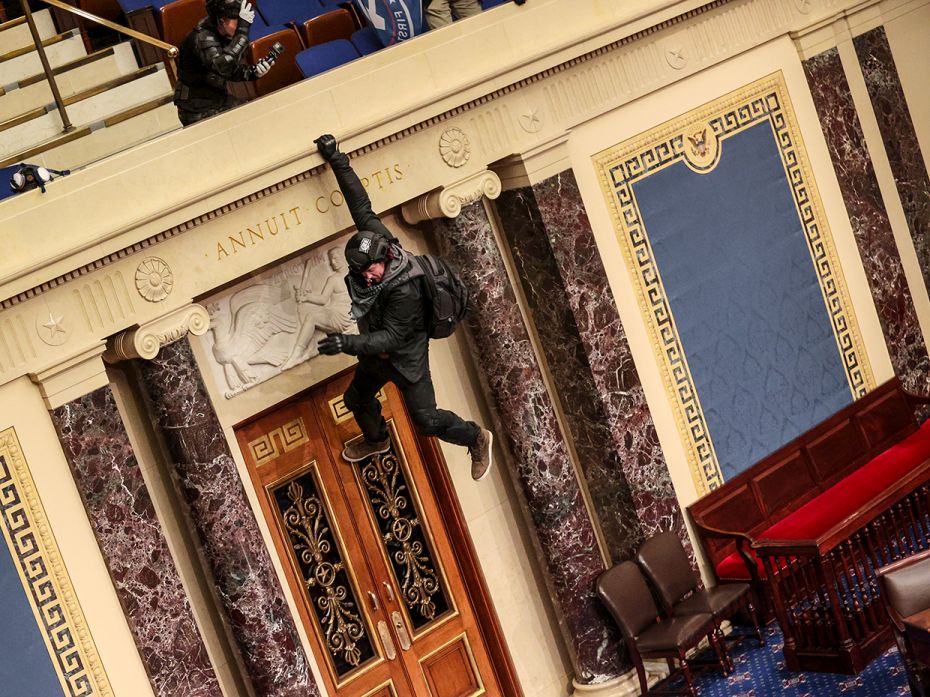 A protester is seen hanging from the balcony in the Senate Chamber on January 06, 2021 in Washington