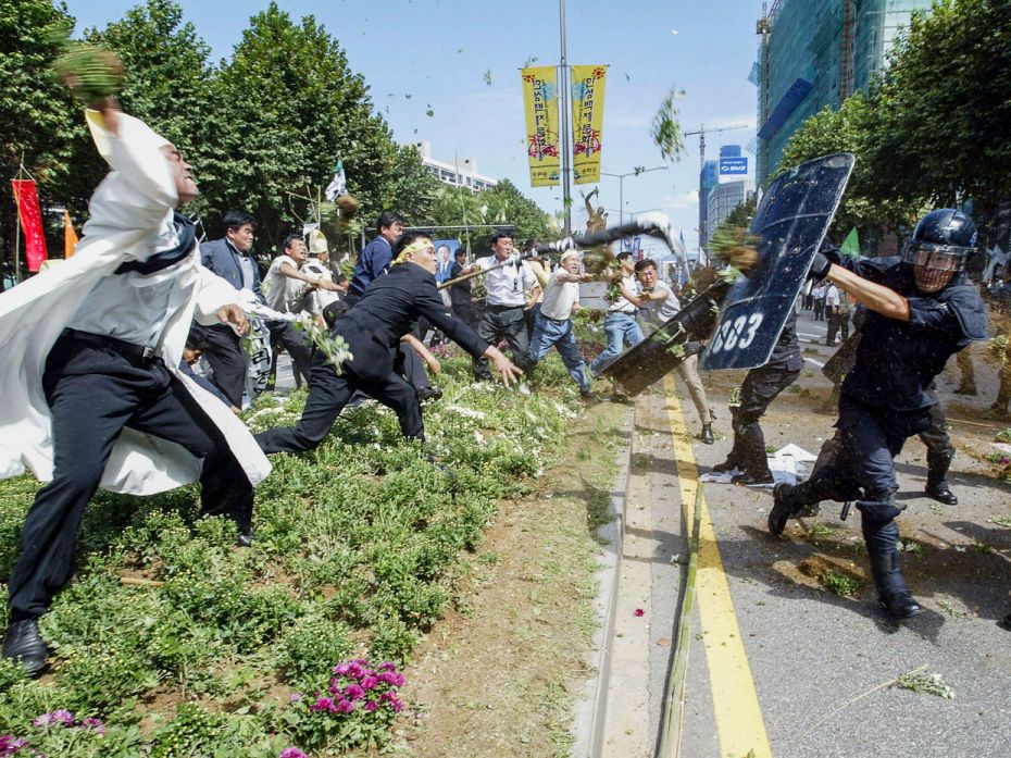 SOUTH KOREA, 2003
South Korean farmers clash with riot police after the funeral ceremony for farm u