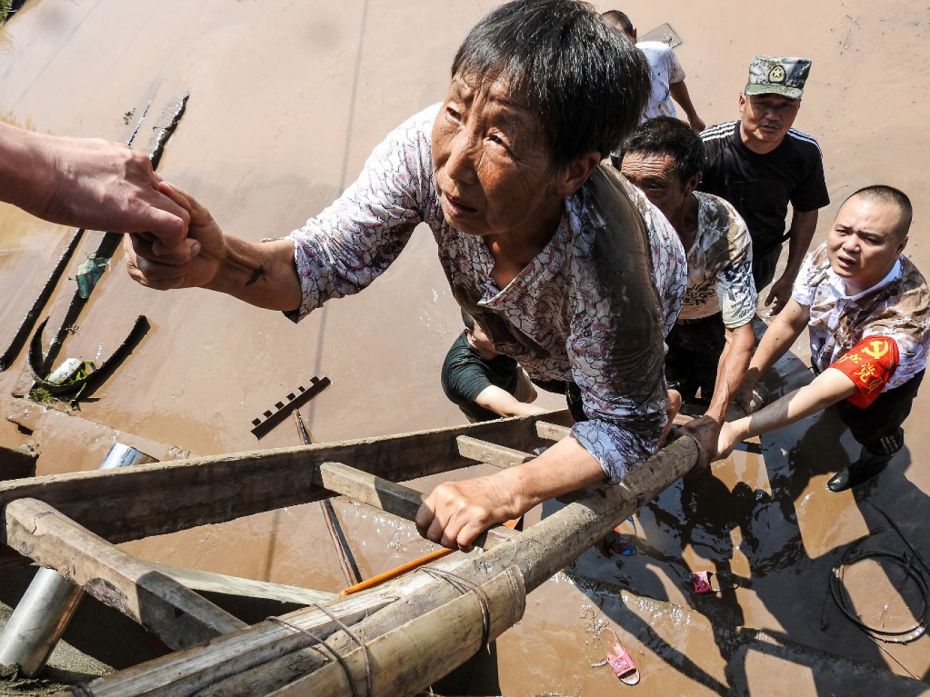 ChinaVillage officials evacuate residents from a flooded area following heavy rains in Dazhou in Chi