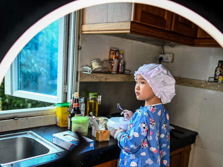 CHEF’S HAT, MYANMAR 
Young chef Moe Myint May Thu films a cooking video at home in Yango