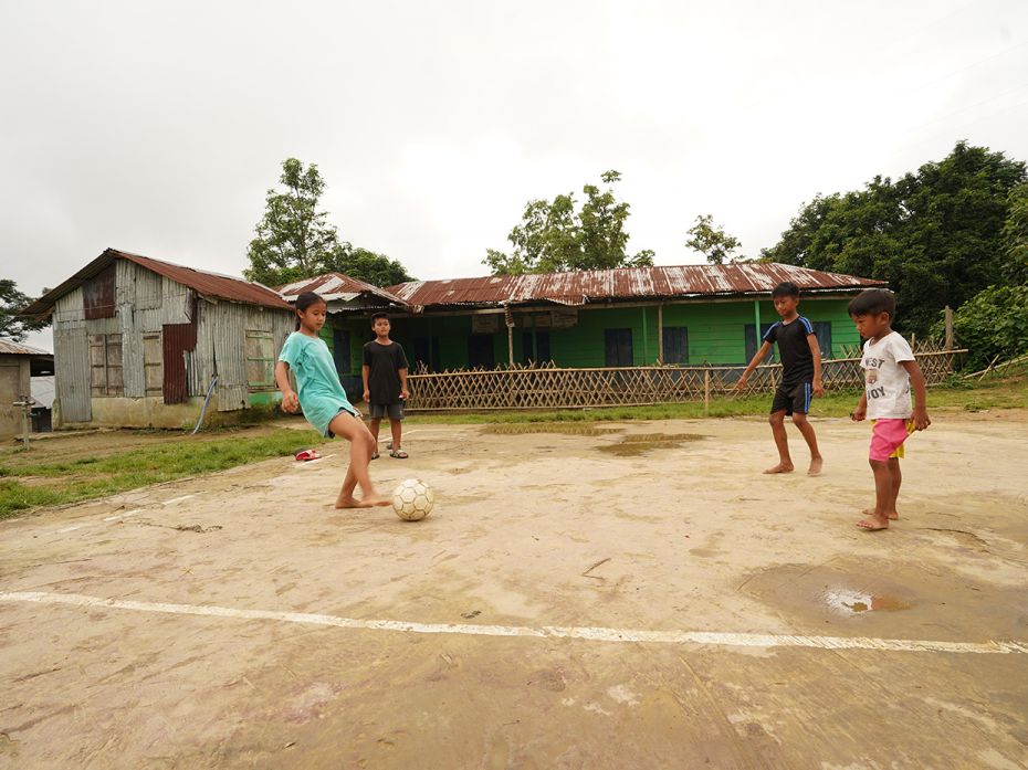 Vanlalnghaki, along with her brother Lalthazuala and friends, playing football barefoot on the volle