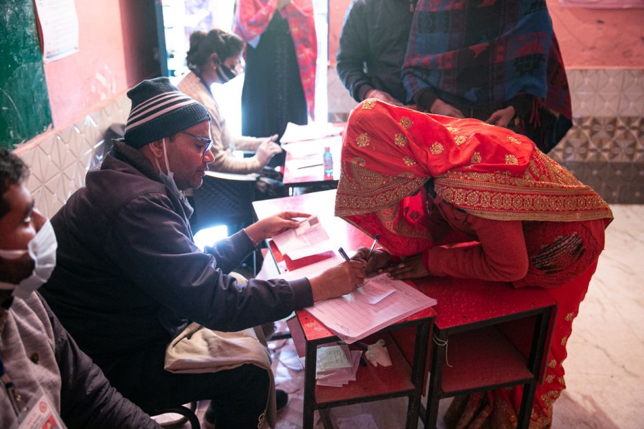 A polling official helps Rajni sign up before she casts her vote at the Mahawatpur booth in Baoli. R