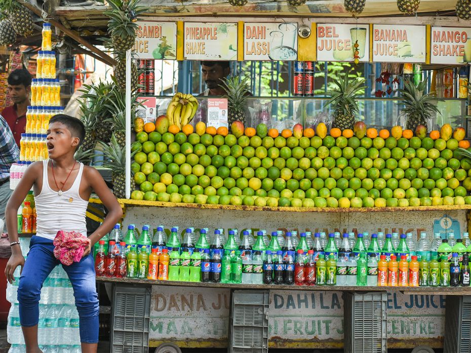 A boy is seen sitting outside a juice shop as he waits for customers, in Kolkata, on 29 April 2022.