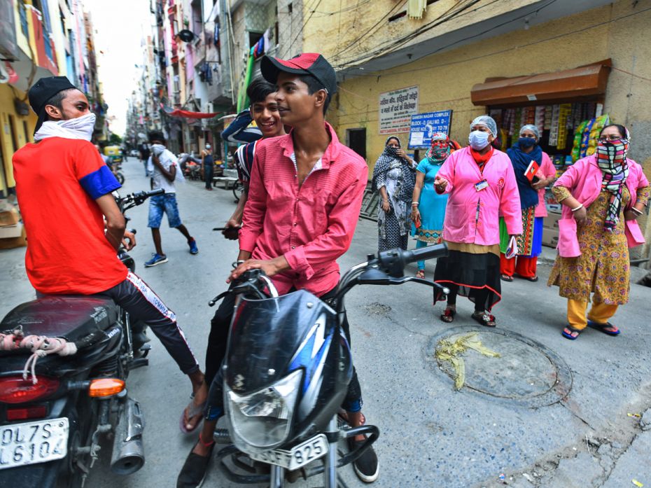 ASHA workers admonish wily teenagers roaming without face masks during a screening survey for corona