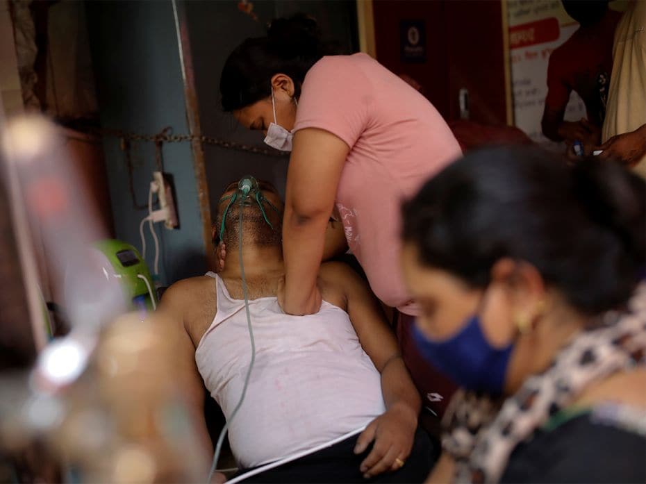 Manisha Bashu presses her father's chest, who is suffering from breathing problems, after he fell un