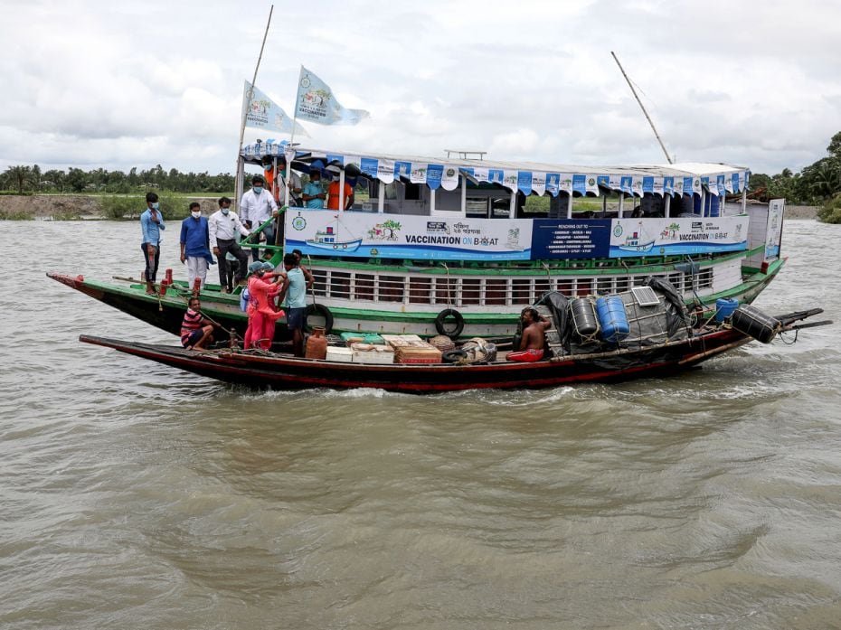 Manobesh Mondol, a fisherman, receives a dose of Covishield vaccine from health workers during the 