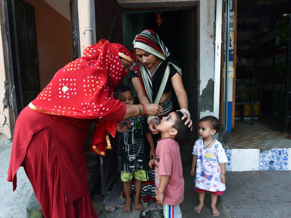 An ASHA worker administers polio drops to a kid during the door to door drive in Gurugram on Septemb