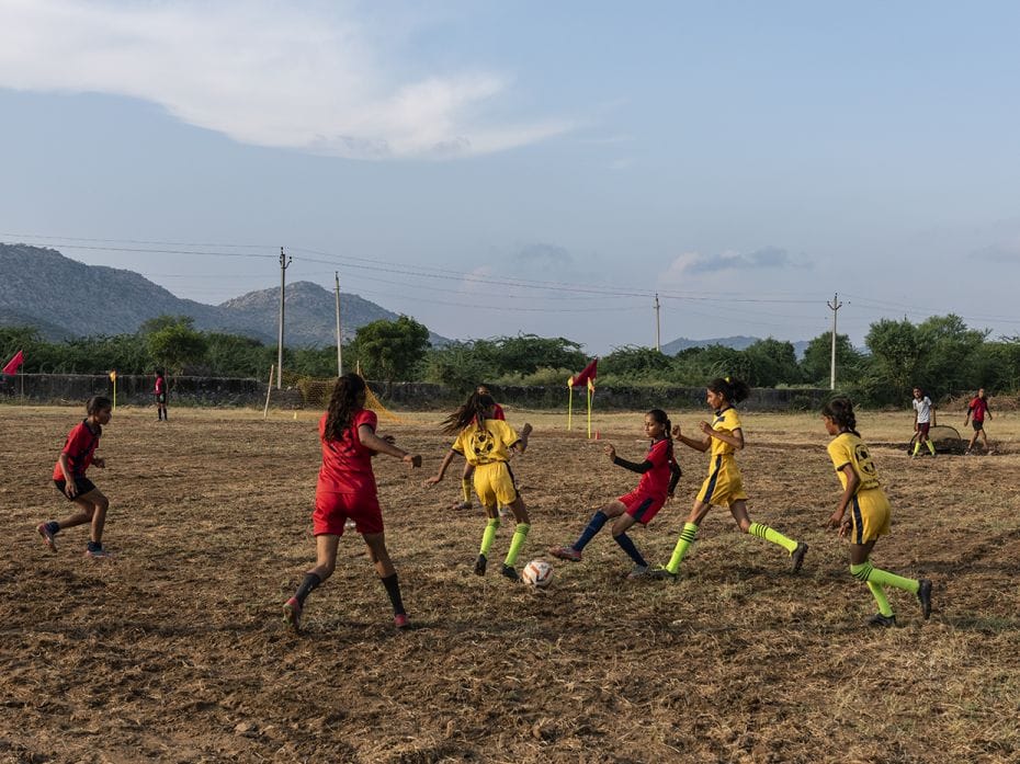 Teams from Chachiyawas and Tedvon Ki Dhani play a friendly match at the football ground of the gover