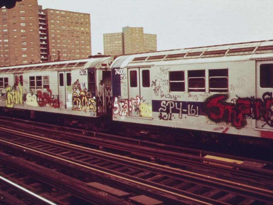 A subway car marked with extensive graffiti tags passes through a station, New York, May 1973. The f