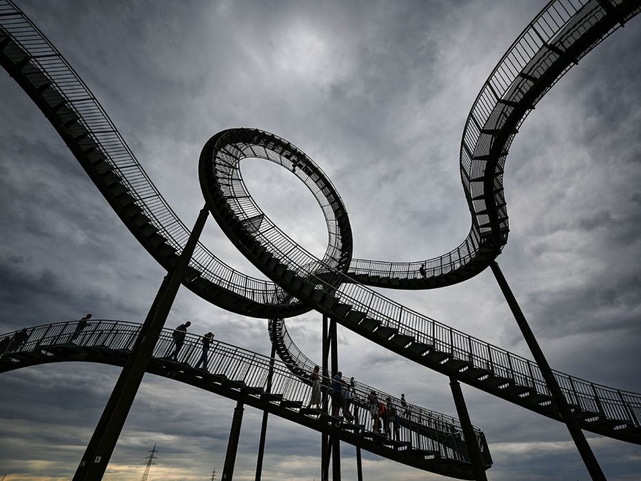 Visitors walk on a large sculpture, 'Tiger and Turtle', by the artists Heike Mutter and Ulrich Genth