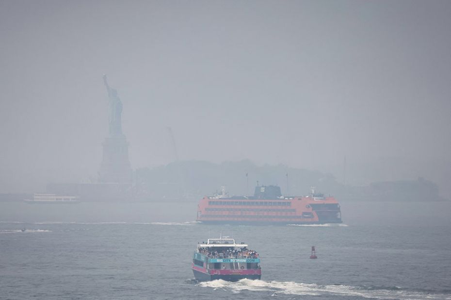 Ferry boats navigate New York Harbor through the haze and smoke from wildfires in Canada, in New Yor