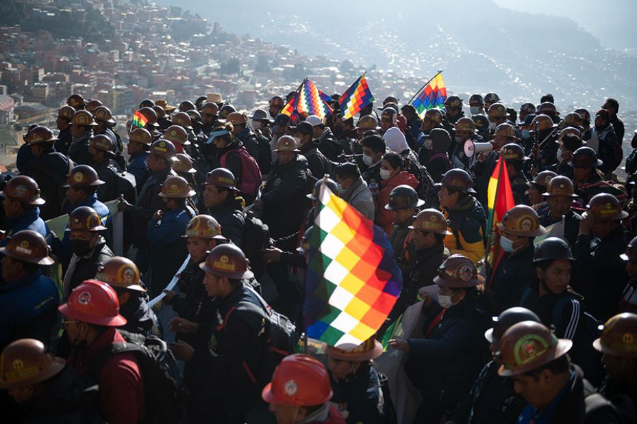 Miners and supporters march with flags and mining helmets during a rally supporting the left-leaning