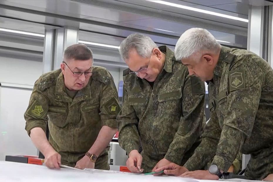 This screengrab shows Russia's Defence Minister Sergei Shoigu (C) and officers looking at a map in a