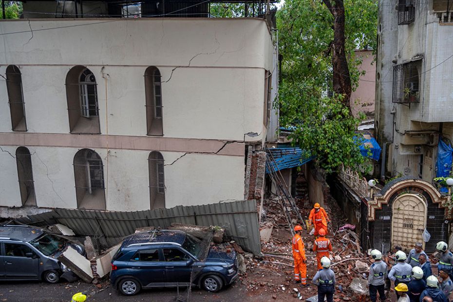 National Disaster Response Force (NDRF) personnel look for survivors at a partially collapsed buildi