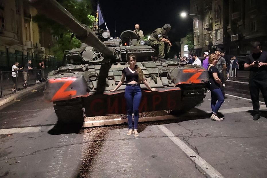 A Russian poses for a photo in front of the Wagner Group military vehicle en route to Rostov-on-Don,