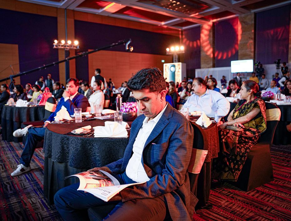 The audience reading the edition of Forbes India on FILA at the event.